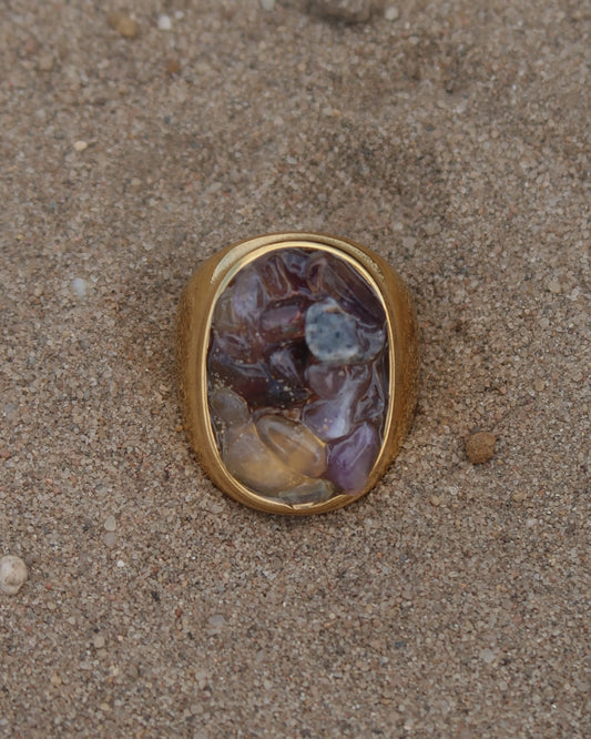 Grote gouden ring van stainless steel met een gladde band en een rechthoekig vlak gevuld met lichtpaarse amethist-achtige steentjes