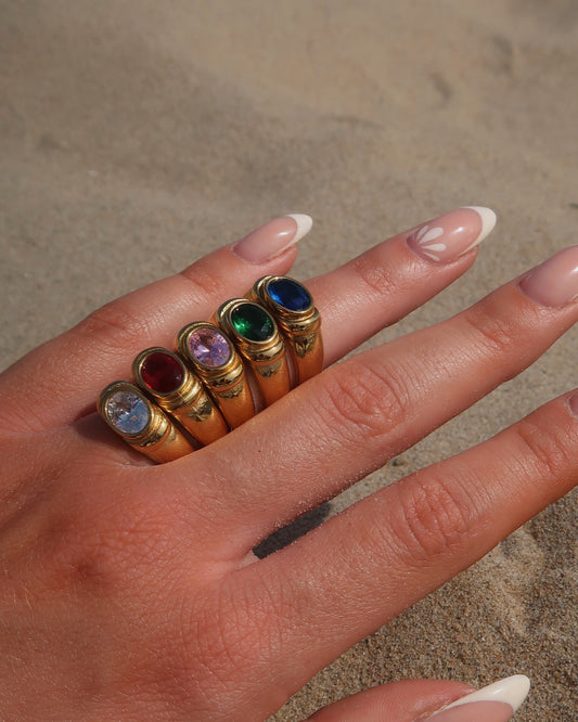 Gouden ring van stainless steel met een gladde band en een opvallende gekleurde steen in het midden