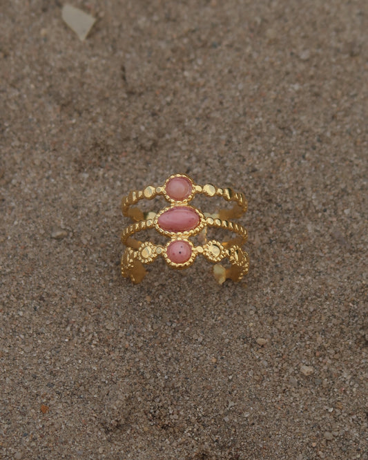 Gouden verstelbare stainless steel ring met drie roze steentjes en verfijnde details, uitgevoerd in een gelaagd design