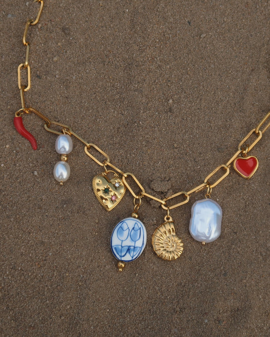 Gouden ketting met zeven bedels, waaronder een chilipeper, hartje en schelp – kleurrijk en speels ontwerp