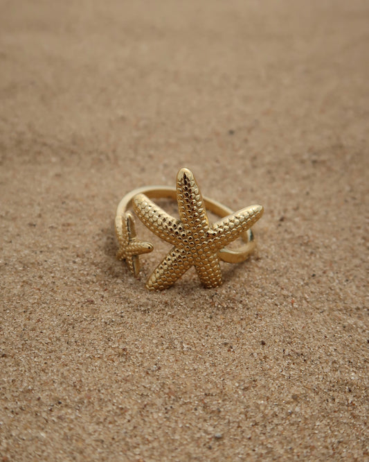 Zanzibar Ring: gouden ring met open design en twee zeesterren. Speelse zomerse look, stainless steel en waterproof.