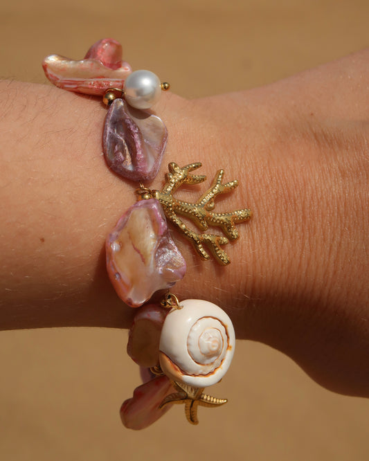 Statement armband van roze schelpen met speelse bedels