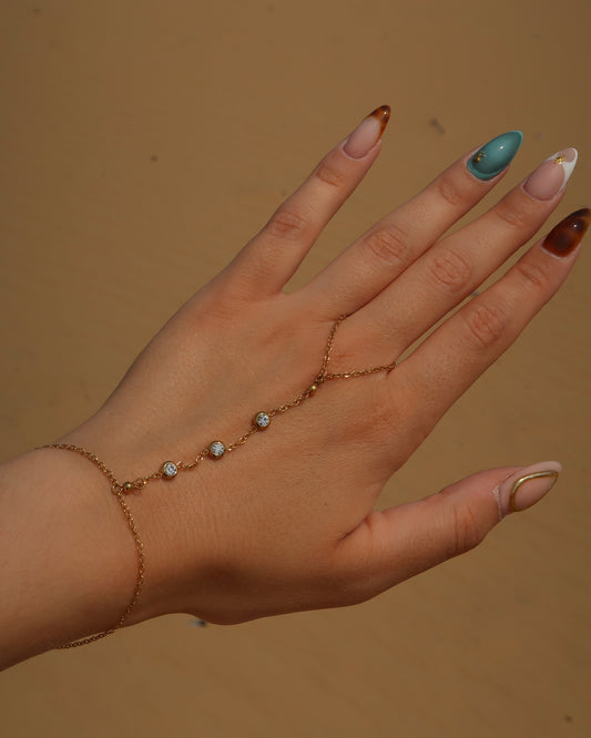 Lume Hand Chain armband voor hand en pols, verkrijgbaar in goud en zilver, stainless steel, waterproof, met drie subtiele steentjes, verstelbaar en ook verkrijgbaar als sieradenset met bijpassende ketting.