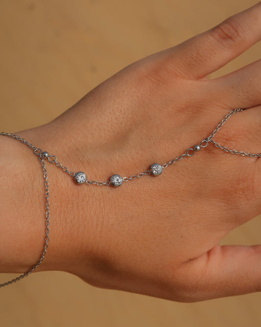 Lume Hand Chain armband voor hand en pols, verkrijgbaar in goud en zilver, stainless steel, waterproof, met drie subtiele steentjes, verstelbaar en ook verkrijgbaar als sieradenset met bijpassende ketting.