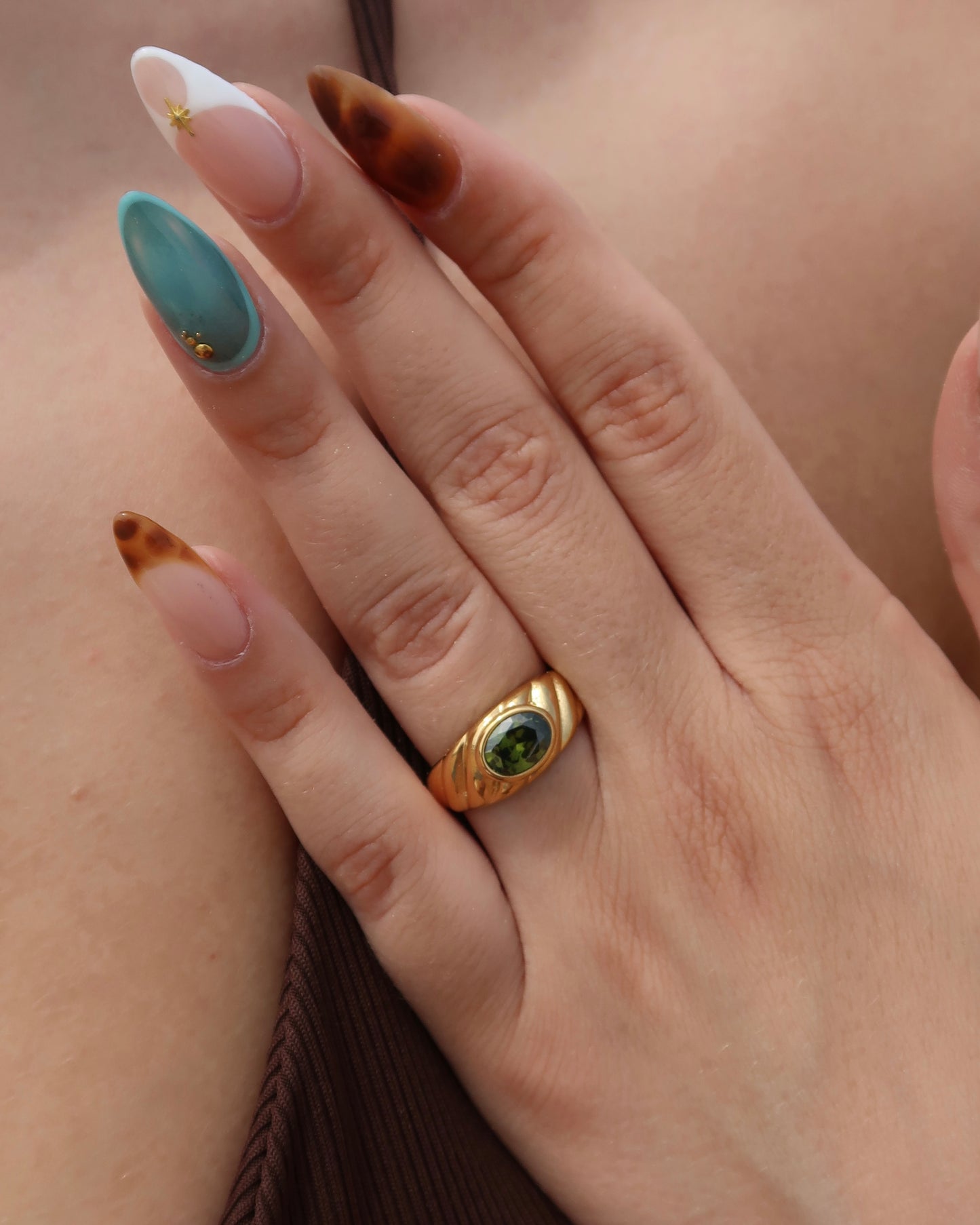 Ember Ring: elegante gouden ring met reliëf en groene steen als eyecatcher. Chique uitstraling, stainless steel en waterproof.