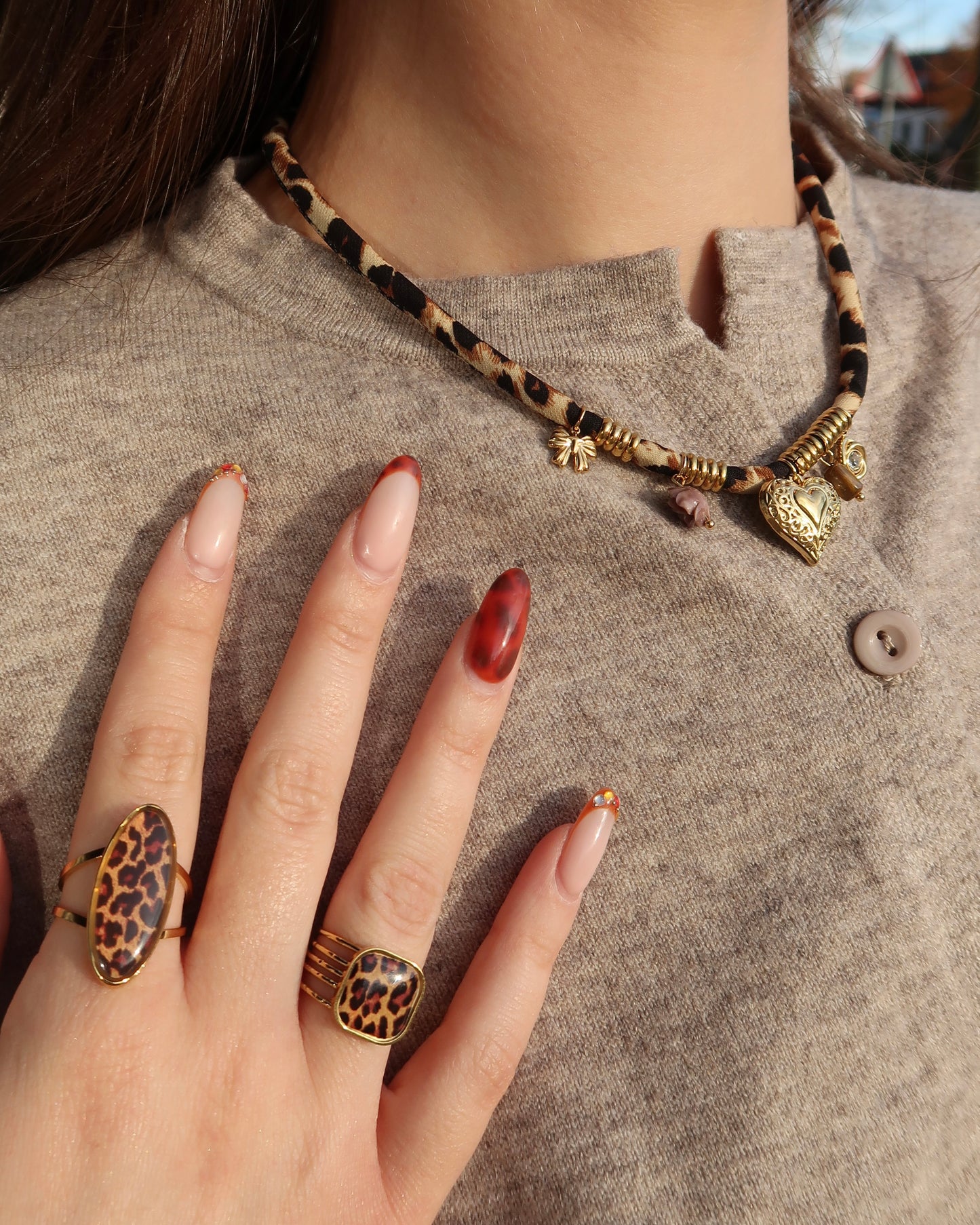 Gouden elastische panterprintketting met kleine hangertjes en verfijnde gouden details.