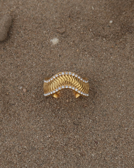 Gouden ring met golvend reliëf en zilverkleurige steentjes langs de randen - gemaakt van stainless steel