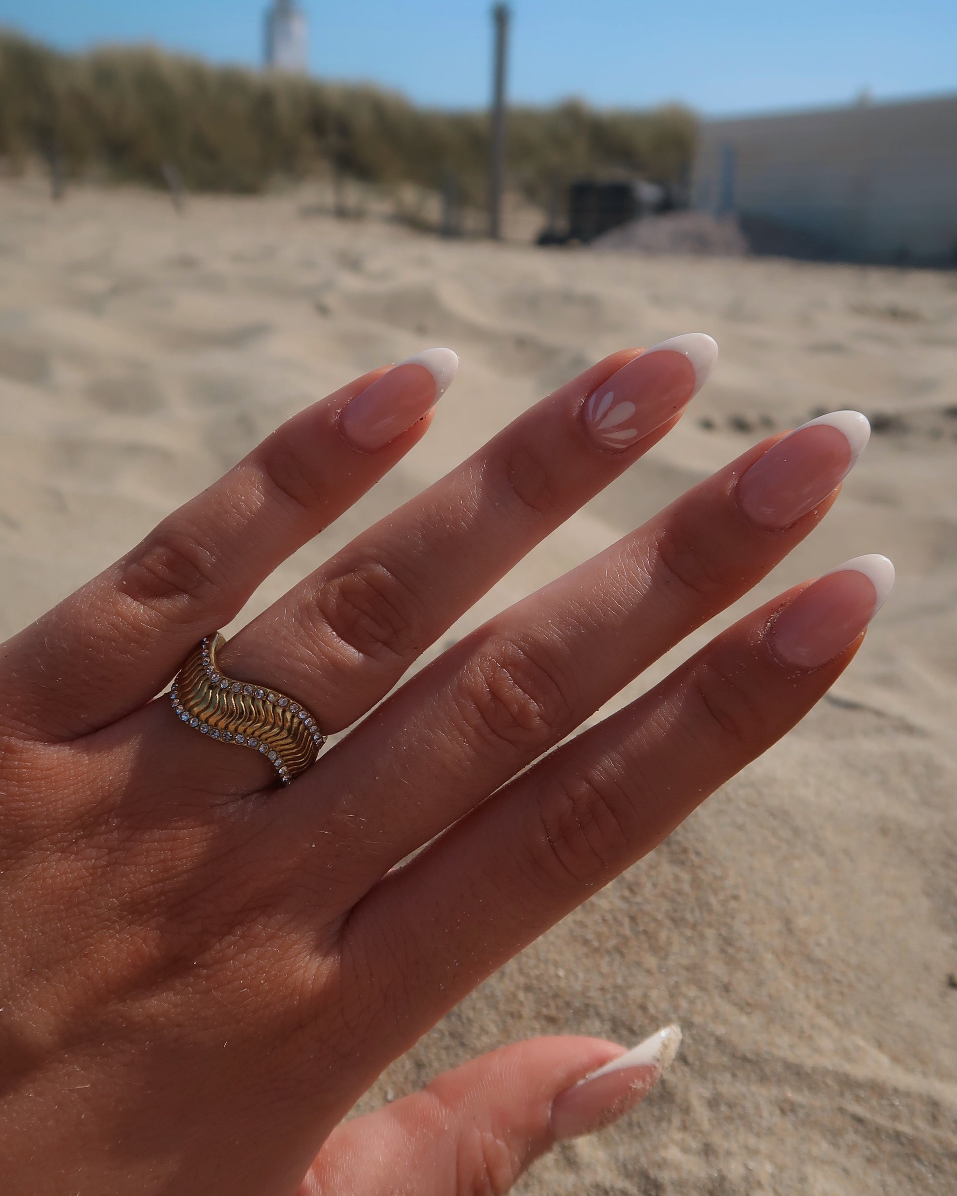 Gouden ring met golvend reliëf en zilverkleurige steentjes langs de randen - gemaakt van stainless steel
