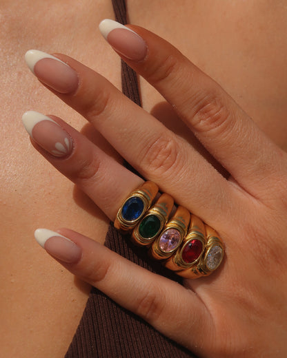 Gouden ring van stainless steel met een gladde band en een opvallende gekleurde steen in het midden