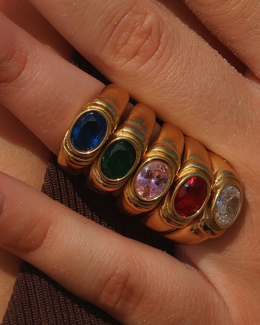 Gouden ring van stainless steel met een gladde band en een opvallende gekleurde steen in het midden