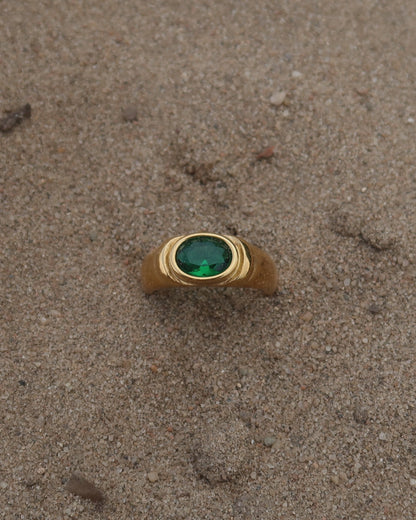 Gouden ring van stainless steel met een gladde band en een opvallende groene steen in het midden