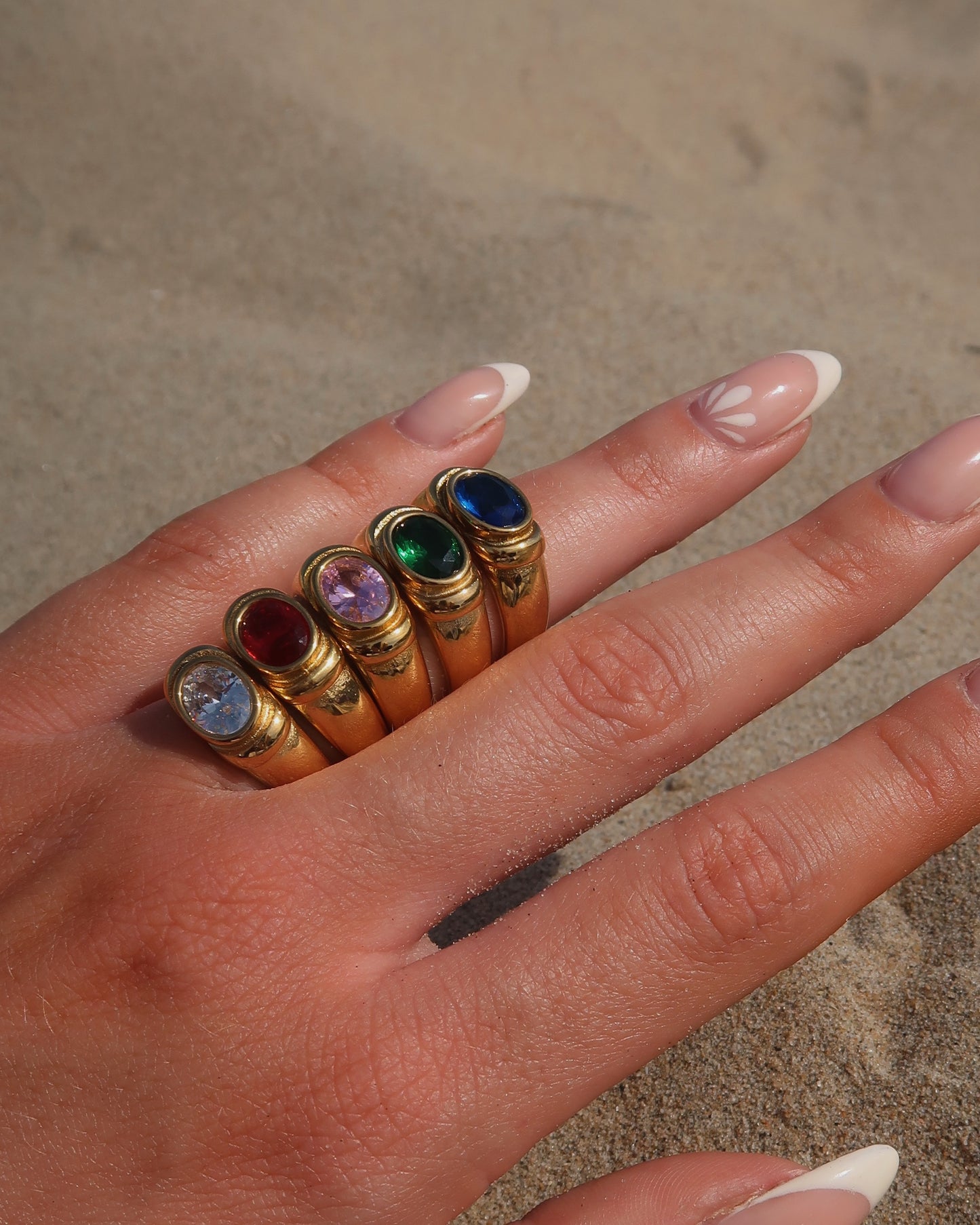 Gouden ring van stainless steel met een gladde band en een opvallende gekleurde steen in het midden