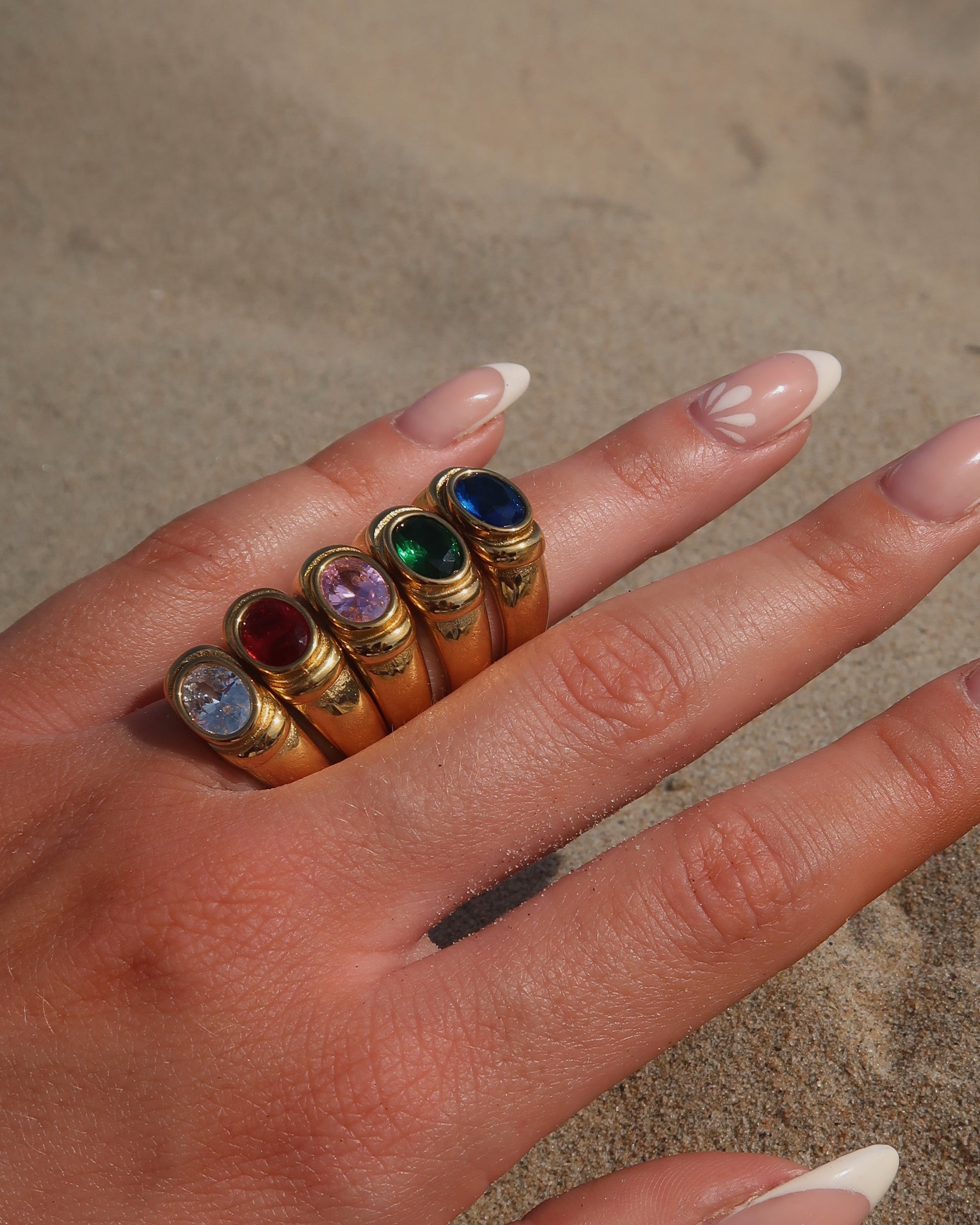 Gouden ring van stainless steel met een gladde band en een opvallende gekleurde steen in het midden