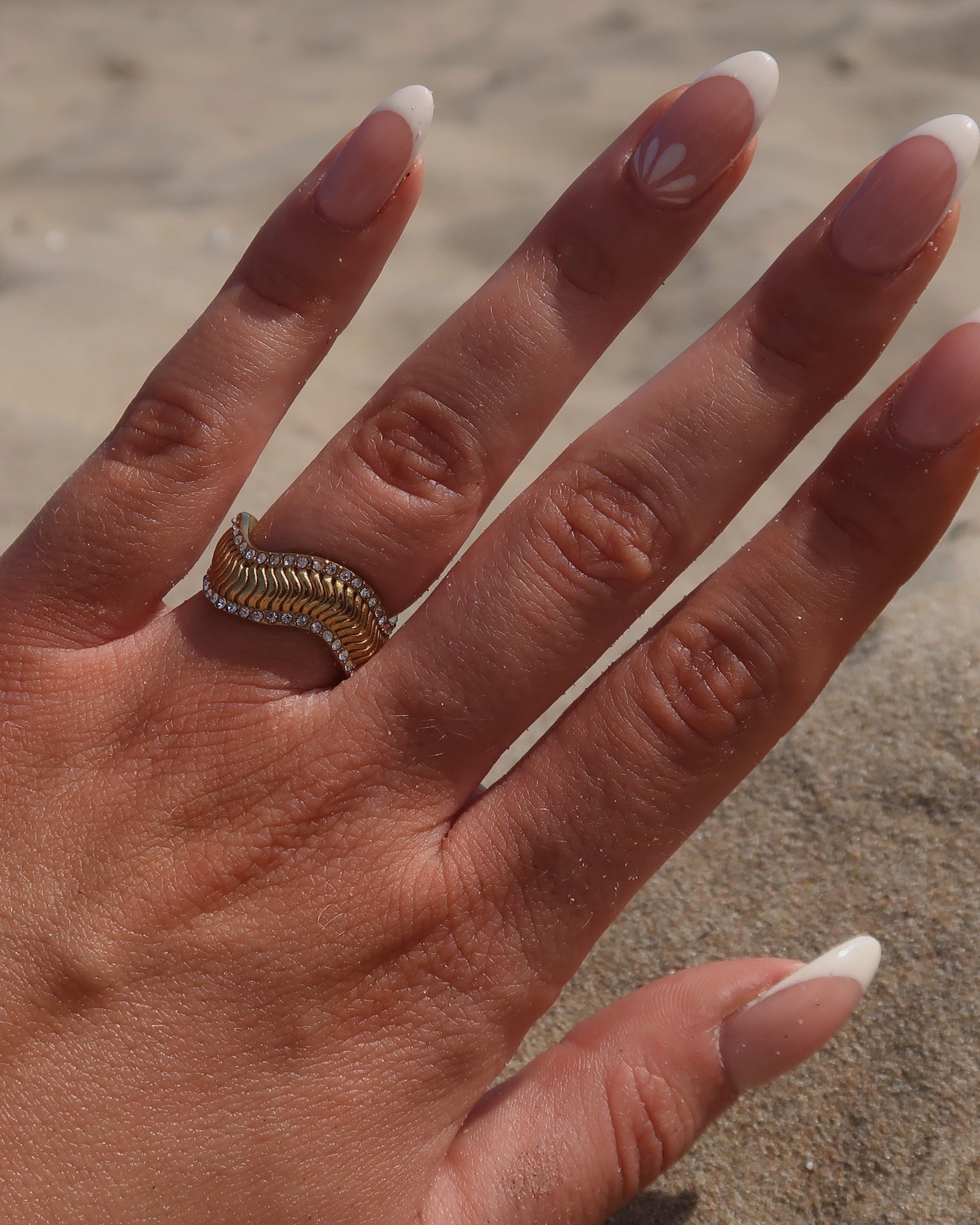 Gouden ring met golvend reliëf en zilverkleurige steentjes langs de randen - gemaakt van stainless steel
