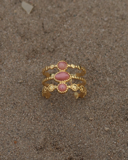 Gouden verstelbare stainless steel ring met drie roze steentjes en verfijnde details, uitgevoerd in een gelaagd design