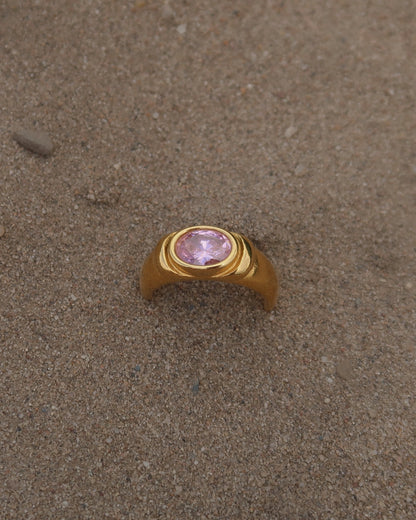 Gouden ring van stainless steel met een gladde band en een opvallende roze steen in het midden