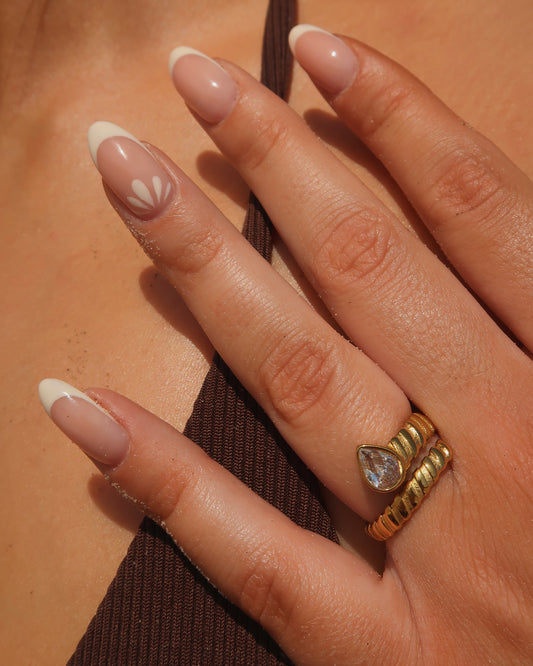 Gouden spiraalvormige ring met reliëf en zilverkleurige druppelvormige steen aan het uiteinde, gemaakt van stainless steel