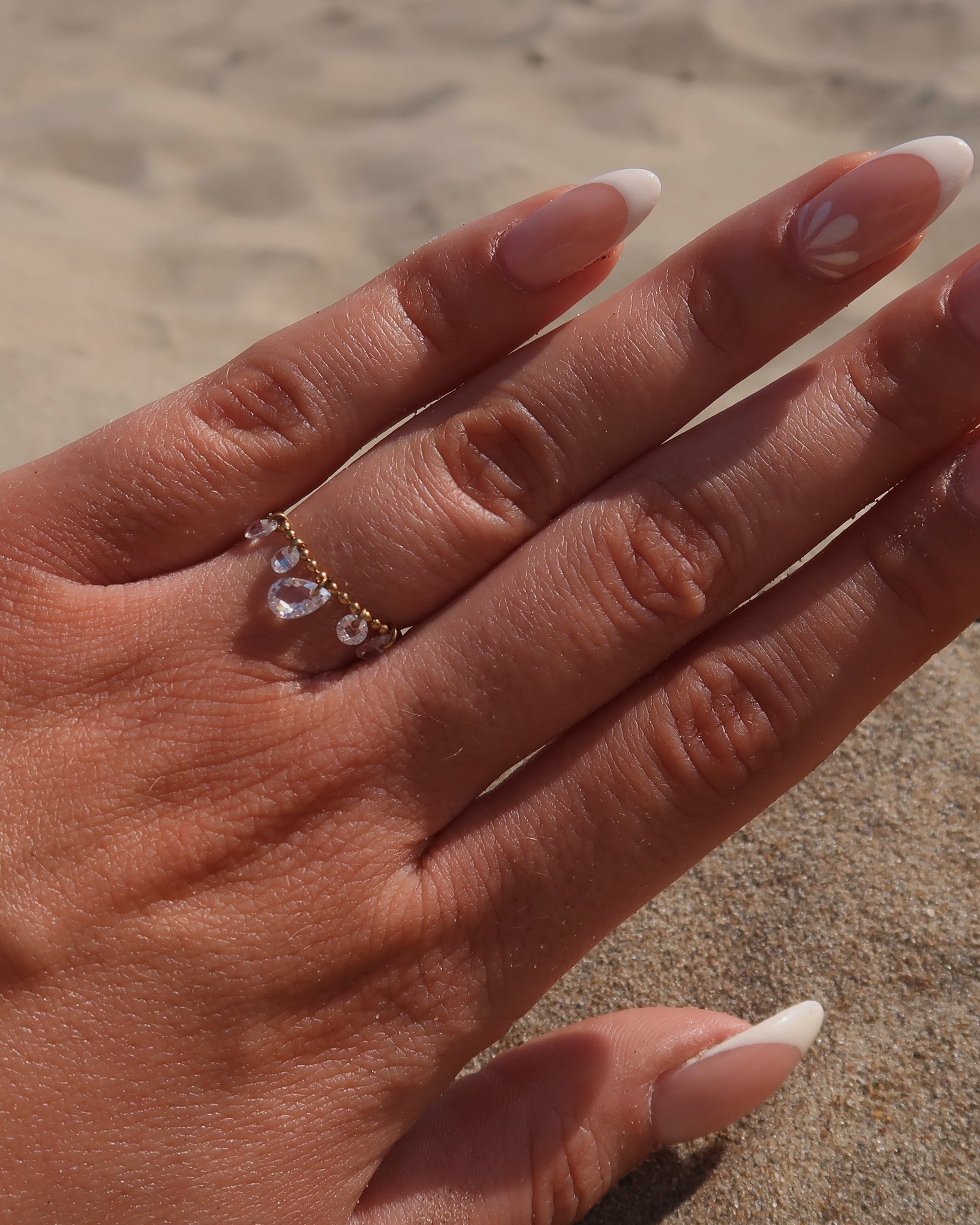 Verstelbare stainless steel ring met bolletjesbandje en hangende druppelvormige steentjes, verkrijgbaar in goud en zilver