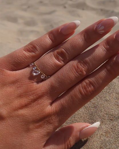 Verstelbare stainless steel ring met bolletjesbandje en hangende druppelvormige steentjes, verkrijgbaar in goud en zilver