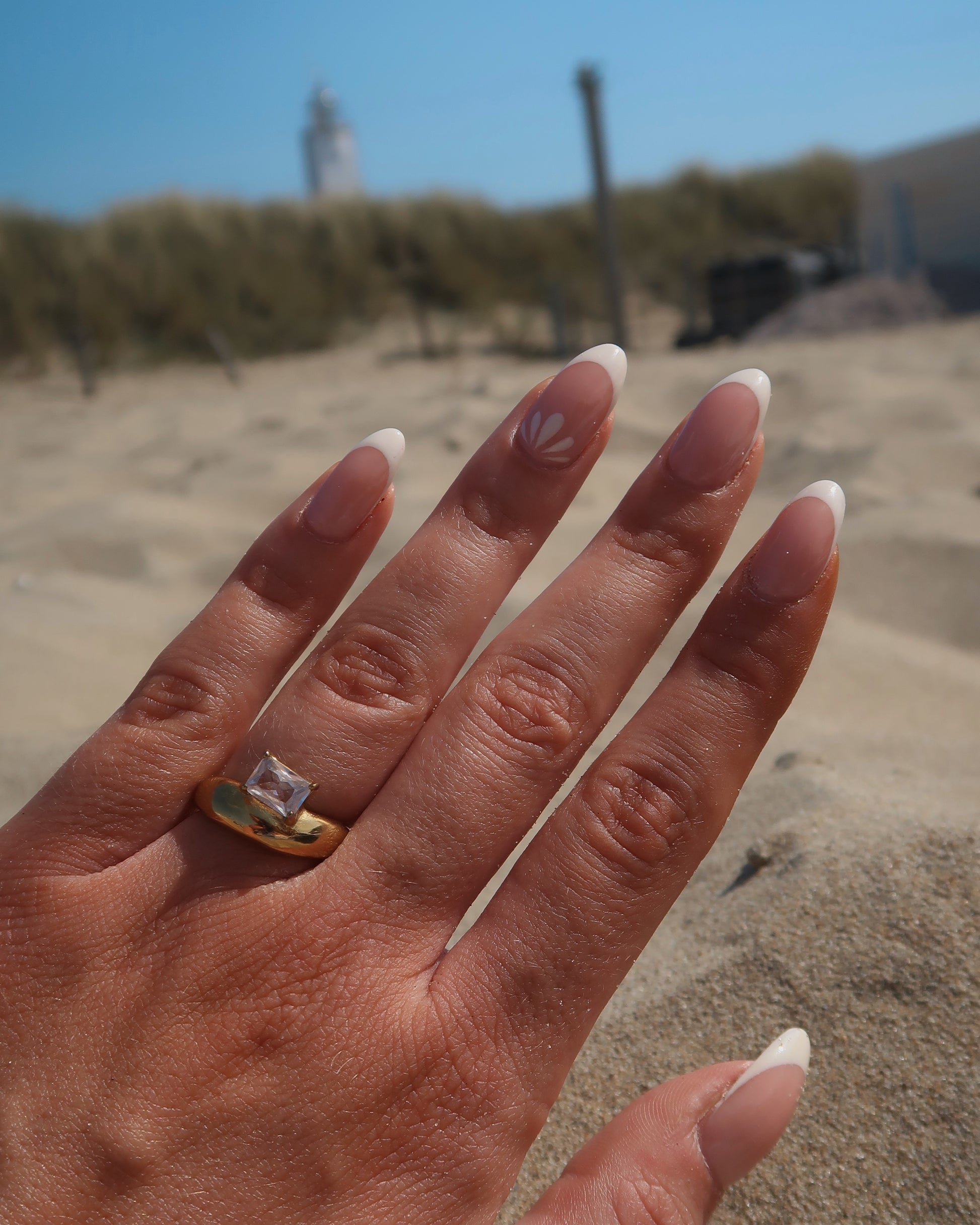 Gouden ring met glad design en een zilverkleurige steen aan de bovenzijde, gemaakt van waterproof stainless steel.