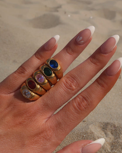 Gouden ring van stainless steel met een gladde band en een opvallende gekleurde steen in het midden