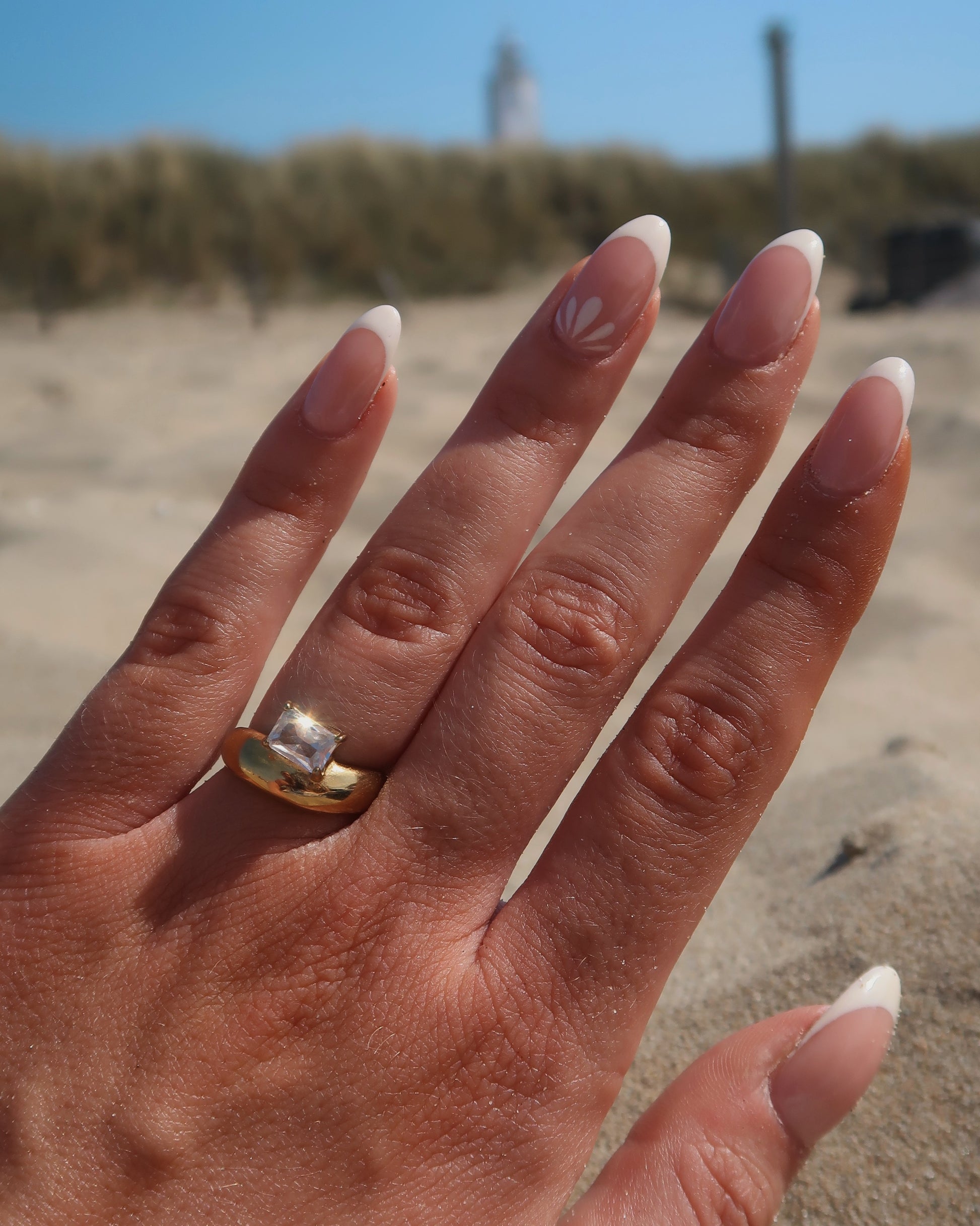 Gouden ring met glad design en een zilverkleurige steen aan de bovenzijde, gemaakt van waterproof stainless steel.