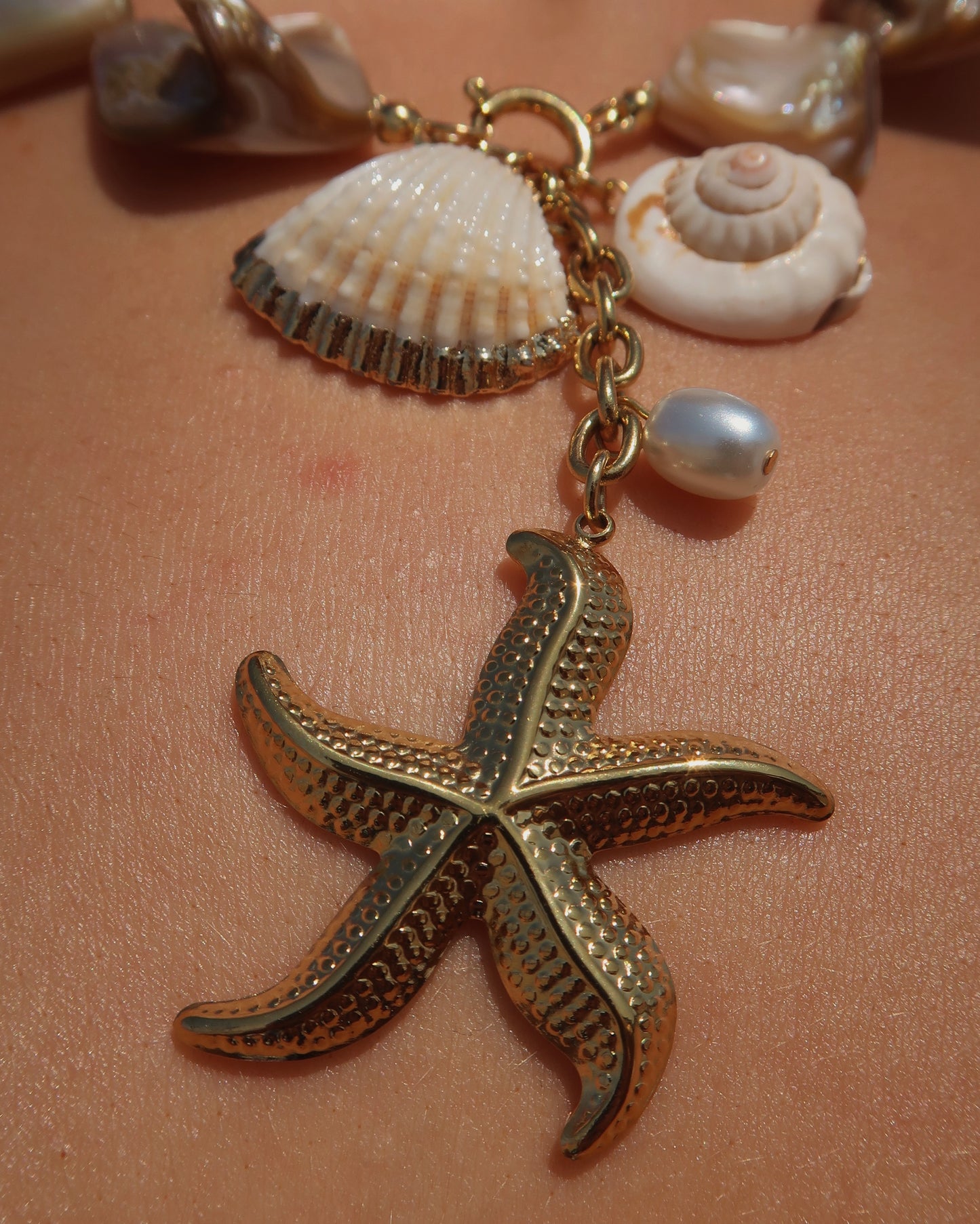 Statement ketting met goudkleurige schelpen en afneembare hangers, waaronder een zeester en schelpen