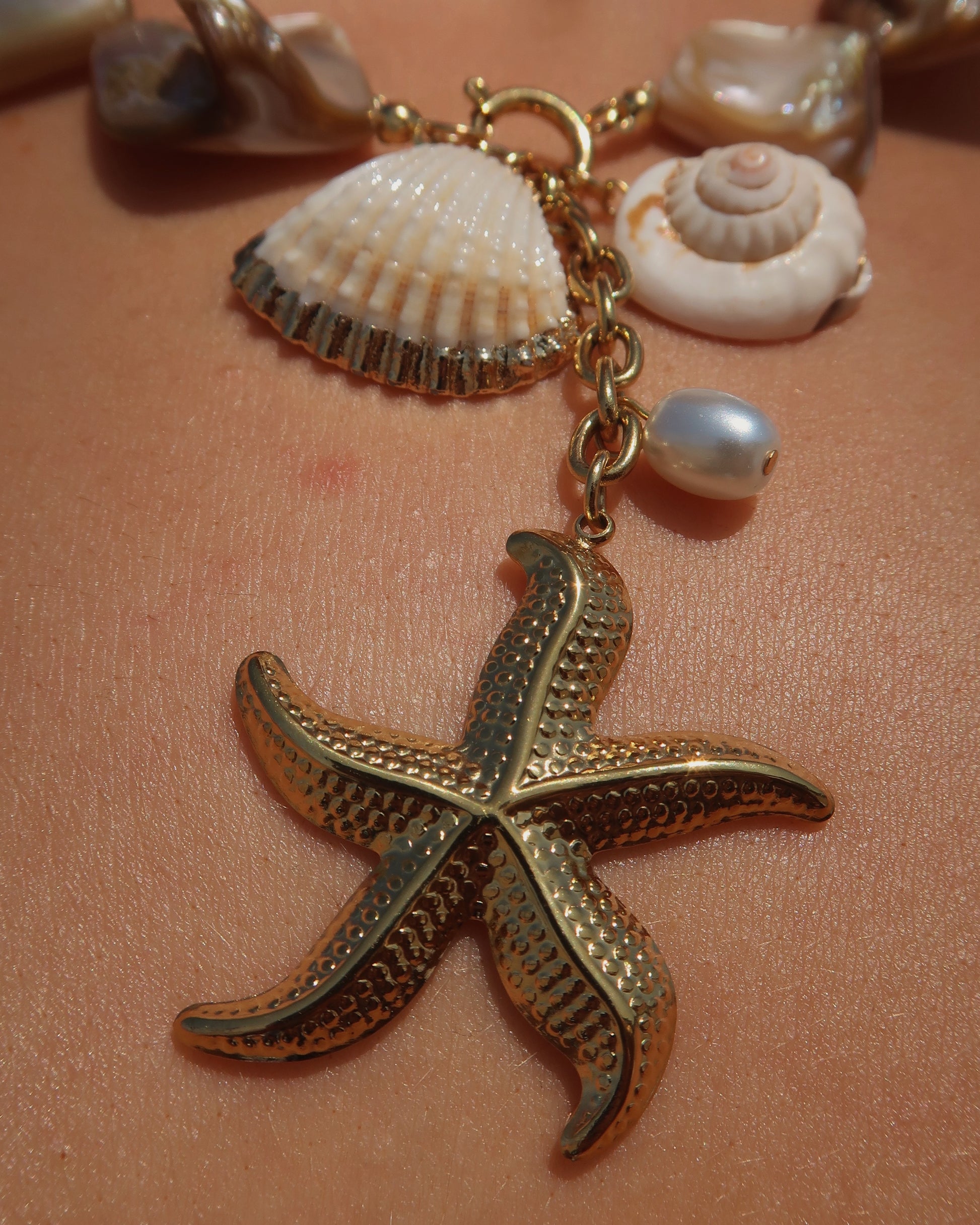 Statement ketting met goudkleurige schelpen en afneembare hangers, waaronder een zeester en schelpen