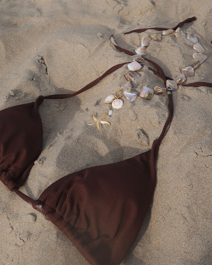 Statement ketting met goudkleurige schelpen en afneembare hangers, waaronder een zeester en schelpen met een bruine bikini