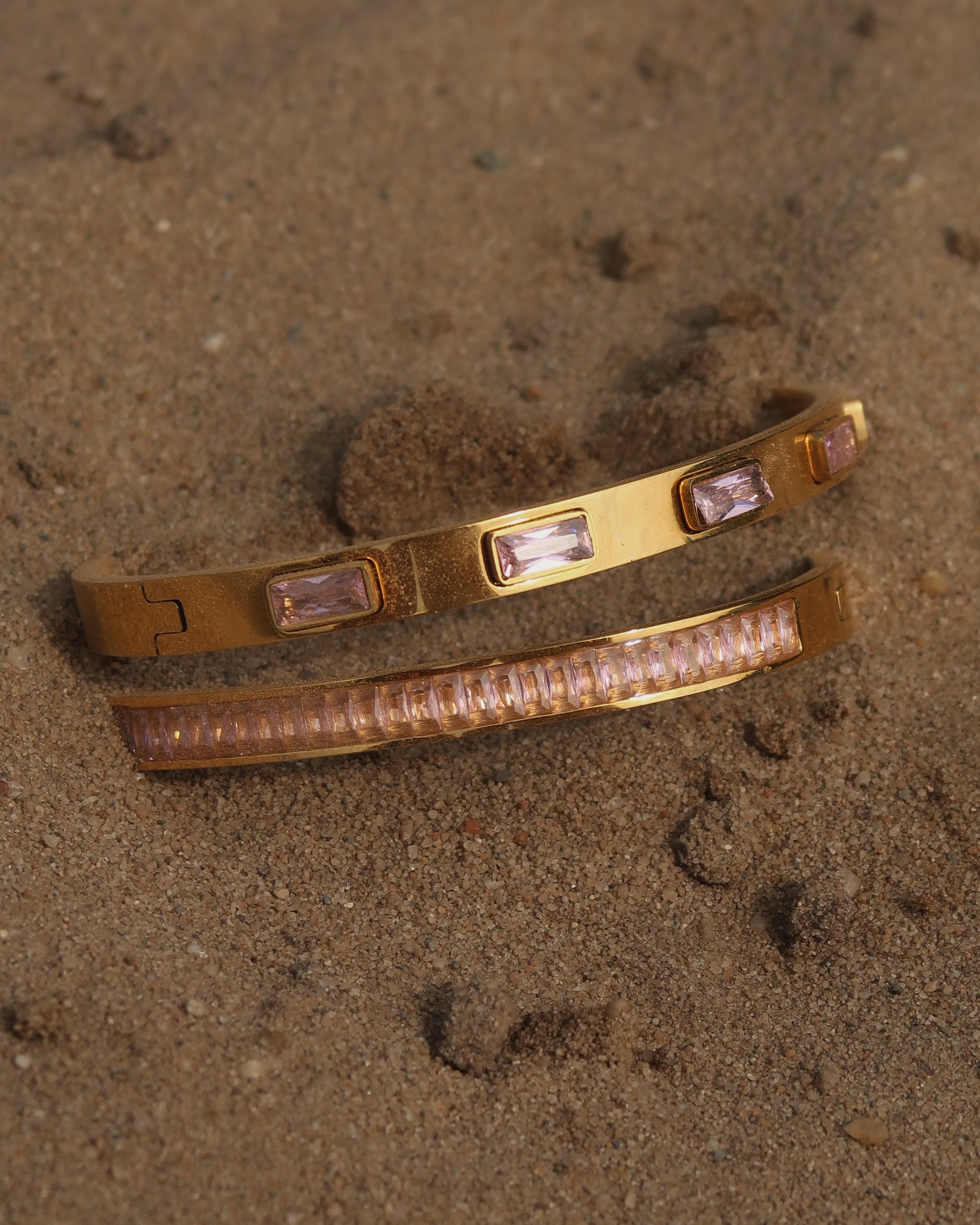 Gouden bangle set met vierkante roze steentjes en roze detail, stainless steel