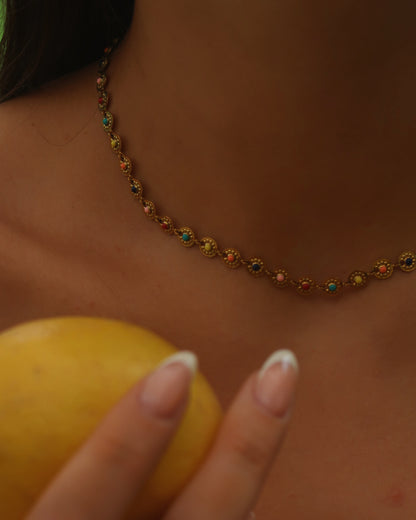 Gouden statement ketting met rondjes en gekleurde bloemdetails