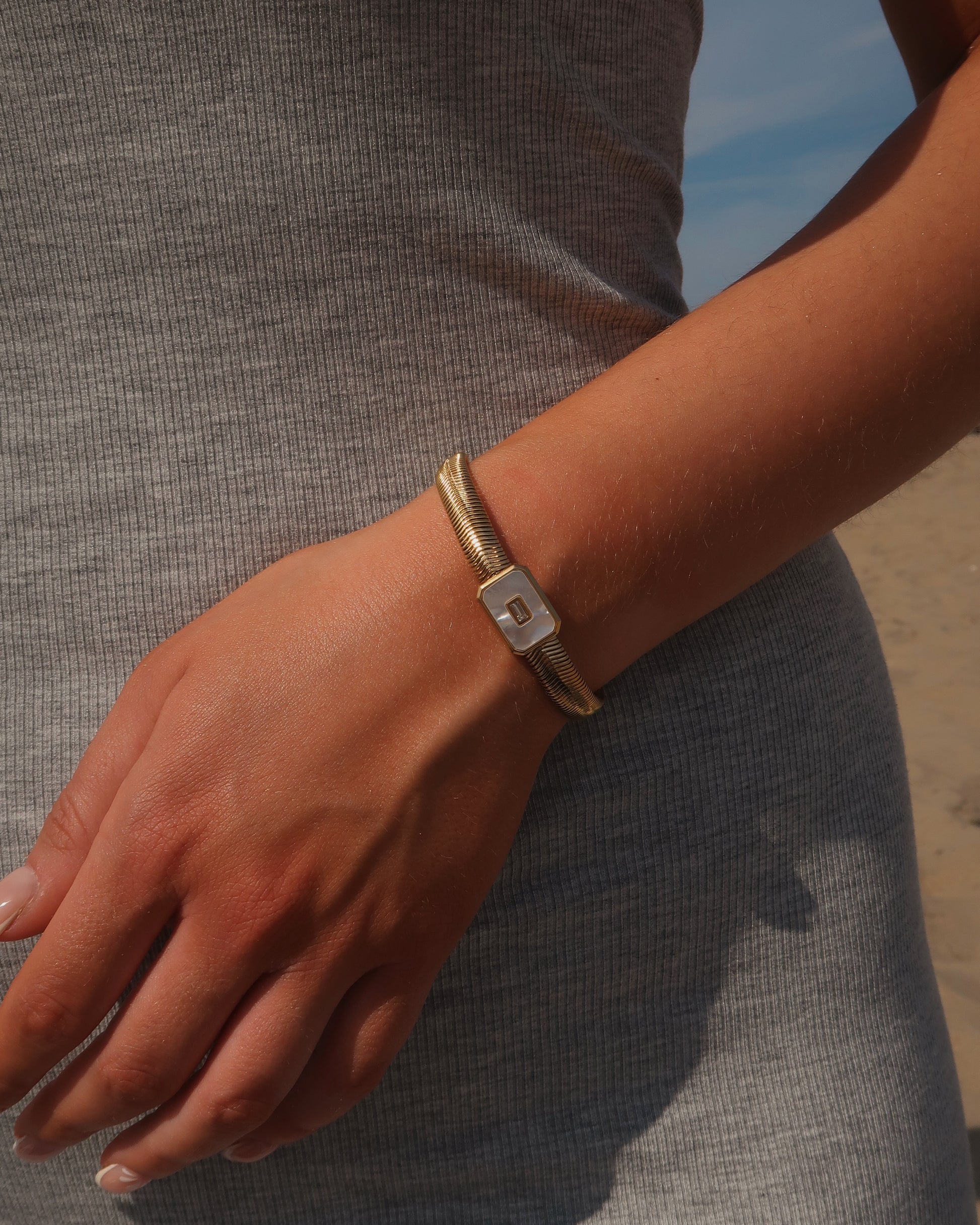 Dolly Bracelet met verfijnd slangenbandje, witte glanzende steen en verstelbare sluiting; waterproof en gemaakt van stainless steel.