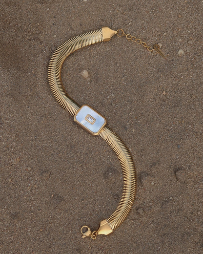 Dolly Bracelet met verfijnd slangenbandje, witte glanzende steen en verstelbare sluiting; waterproof en gemaakt van stainless steel.