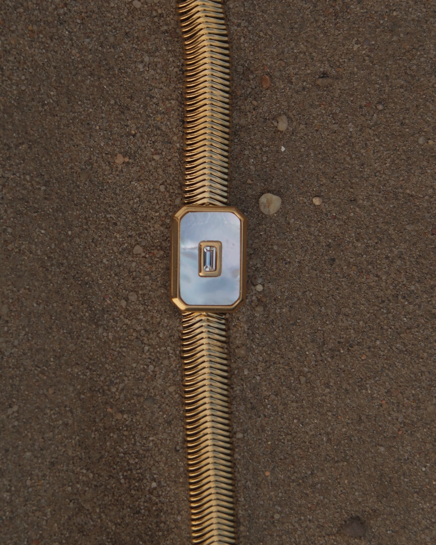 Dolly Bracelet met verfijnd slangenbandje, witte glanzende steen en verstelbare sluiting; waterproof en gemaakt van stainless steel.