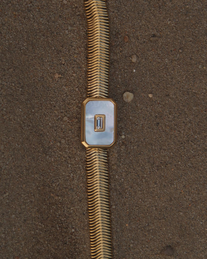 Dolly Bracelet met verfijnd slangenbandje, witte glanzende steen en verstelbare sluiting; waterproof en gemaakt van stainless steel.