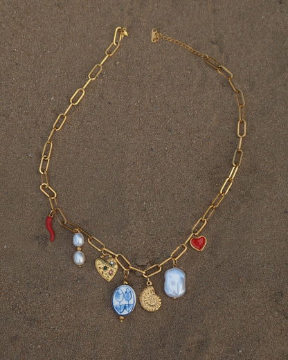 Gouden ketting met zeven bedels, waaronder een chilipeper, hartje en schelp – kleurrijk en speels ontwerp