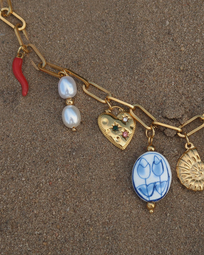 Gouden ketting met zeven bedels, waaronder een chilipeper, hartje en schelp – kleurrijk en speels ontwerp