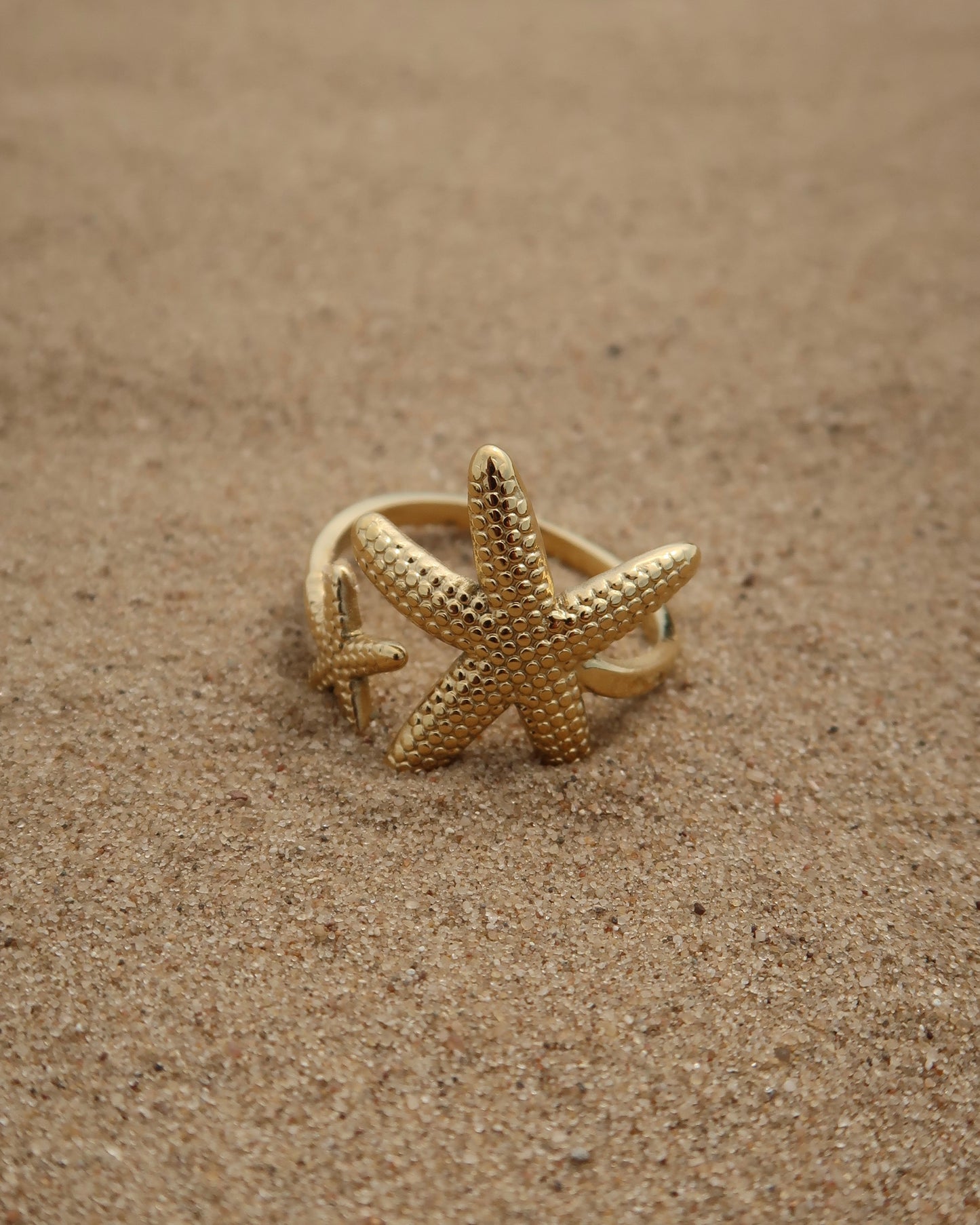 Zanzibar Ring: gouden ring met open design en twee zeesterren. Speelse zomerse look, stainless steel en waterproof.