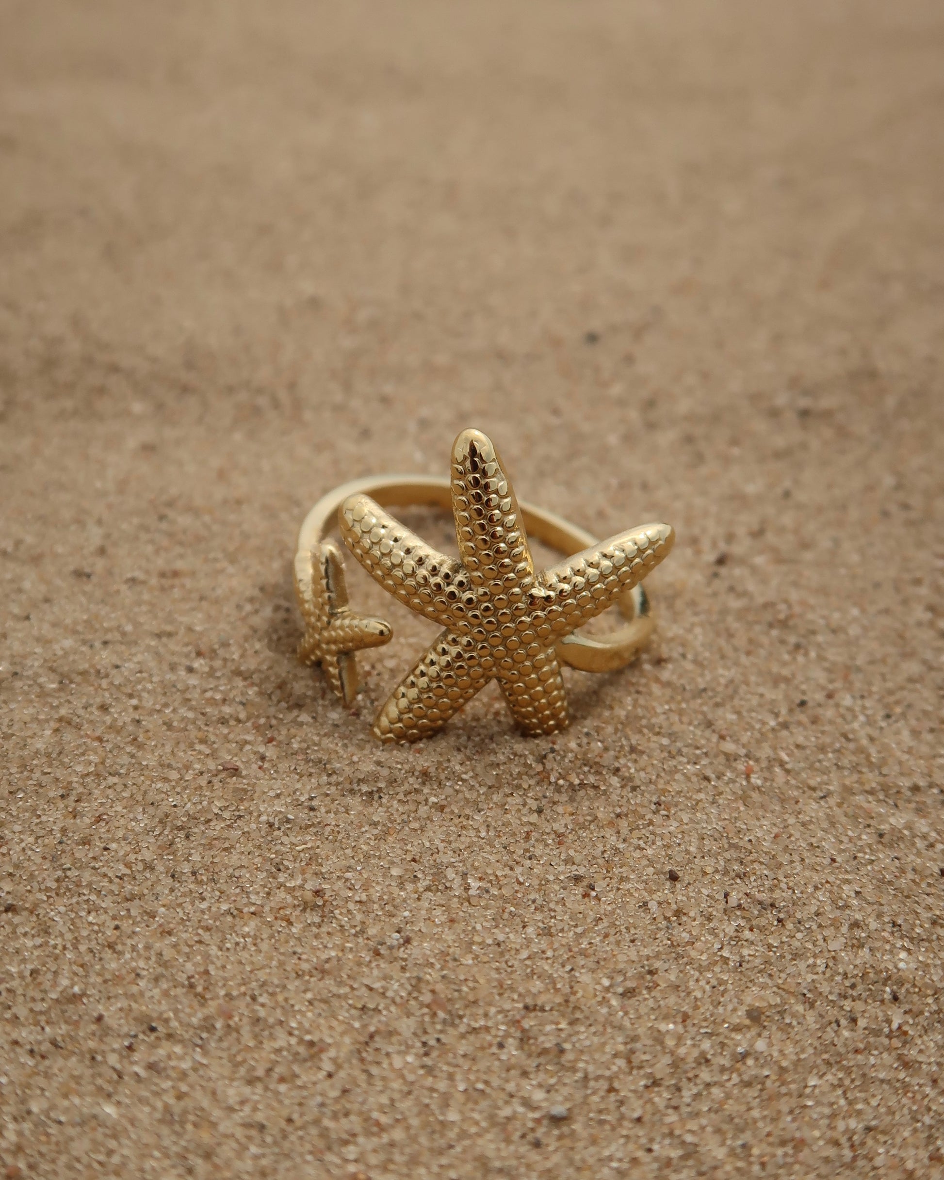 Zanzibar Ring: gouden ring met open design en twee zeesterren. Speelse zomerse look, stainless steel en waterproof.