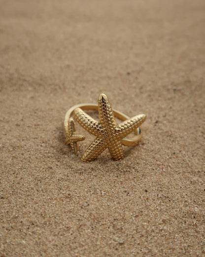 Zanzibar Ring: gouden ring met open design en twee zeesterren. Speelse zomerse look, stainless steel en waterproof.