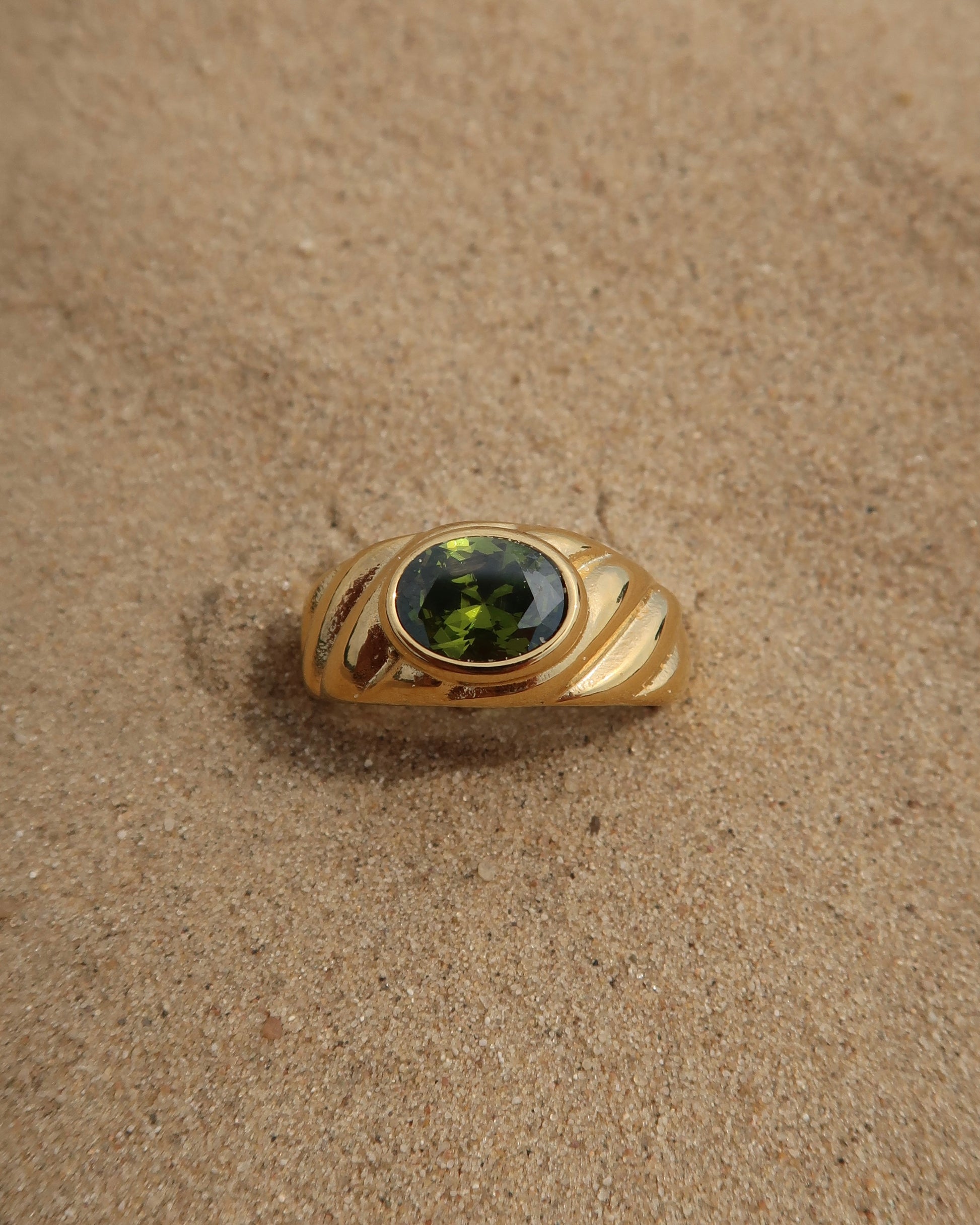 Ember Ring: elegante gouden ring met reliëf en groene steen als eyecatcher. Chique uitstraling, stainless steel en waterproof.
