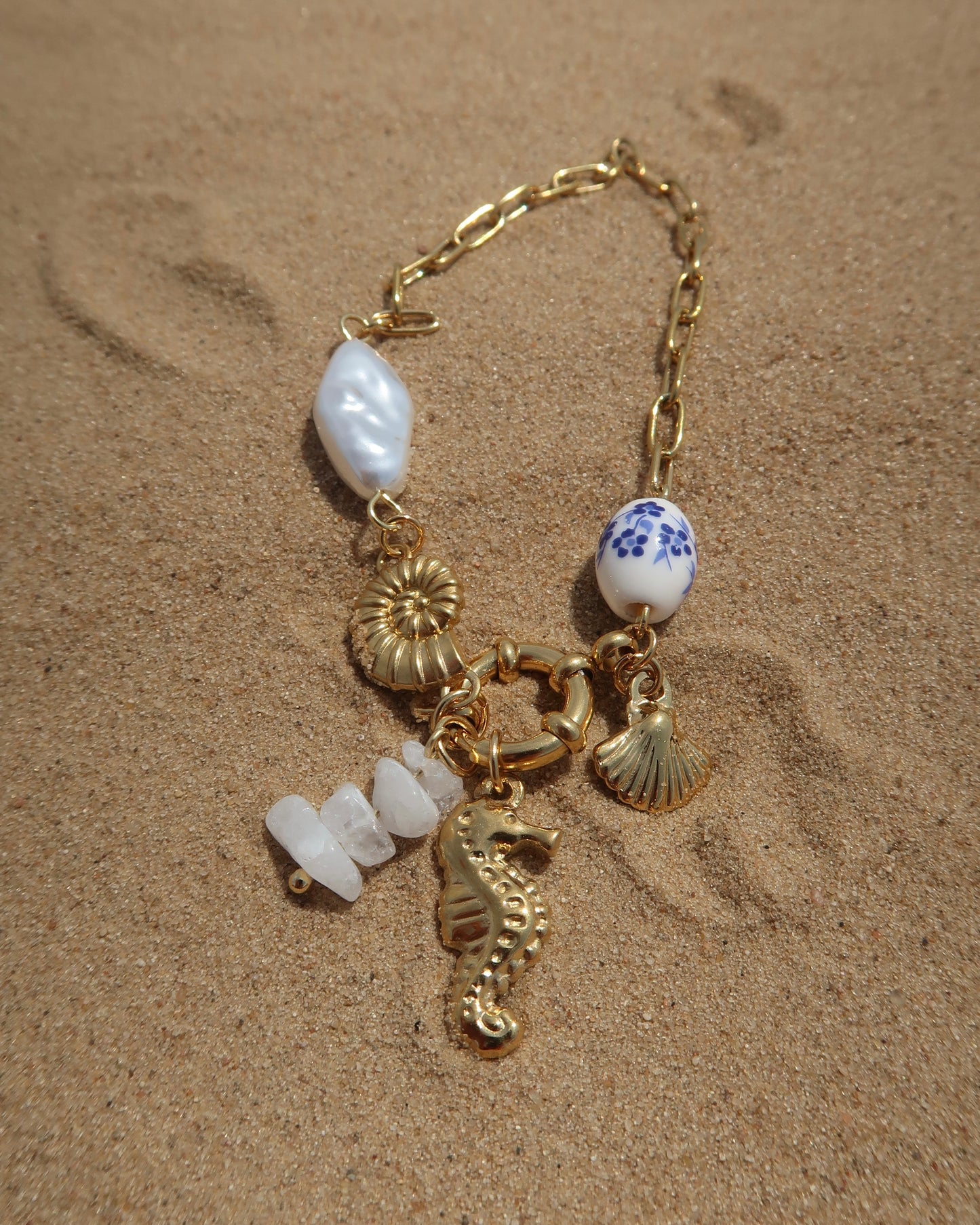 Goude bedelarmband van stainless steel met een zeepaard, schelpen en parels