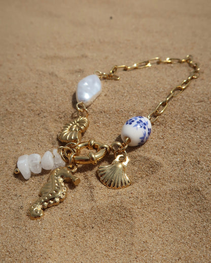 Goude bedelarmband van stainless steel met een zeepaard, schelpen en parels