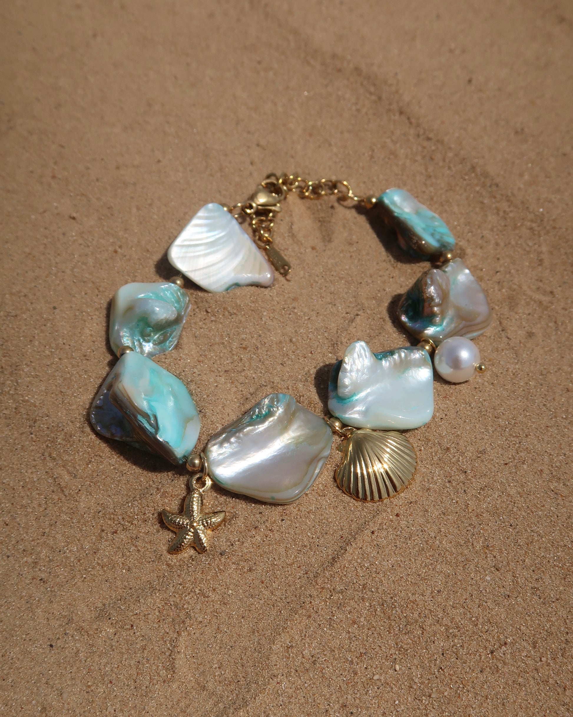 Statement armband van blauwe schelpen met speelse bedels