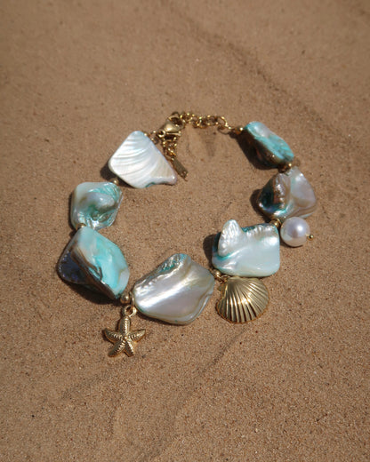 Statement armband van blauwe schelpen met speelse bedels