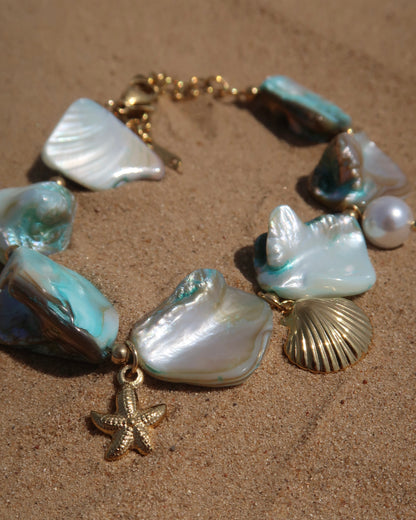 Statement armband van blauwe schelpen met speelse bedels