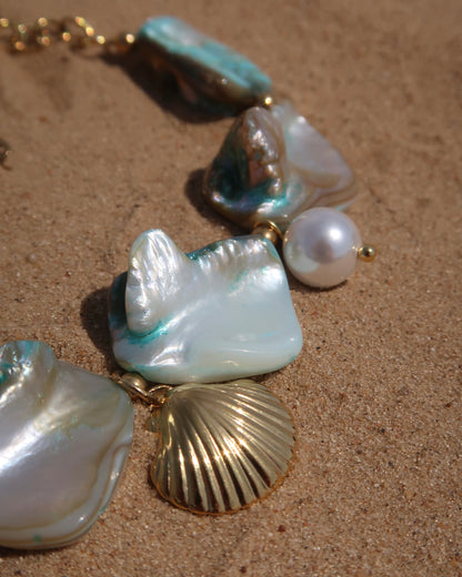 Statement armband van blauwe schelpen met speelse bedels