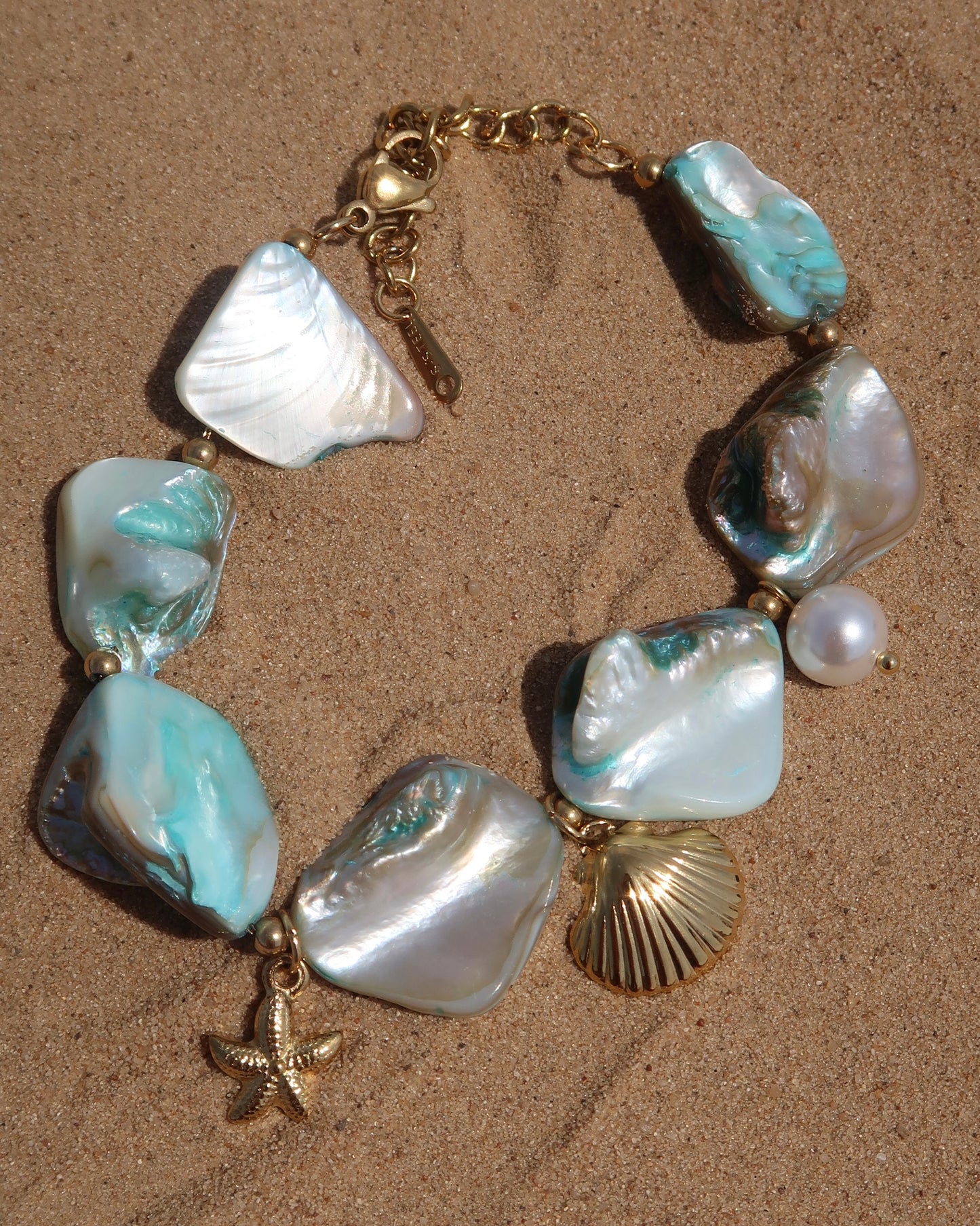 Statement armband van blauwe schelpen met speelse bedels