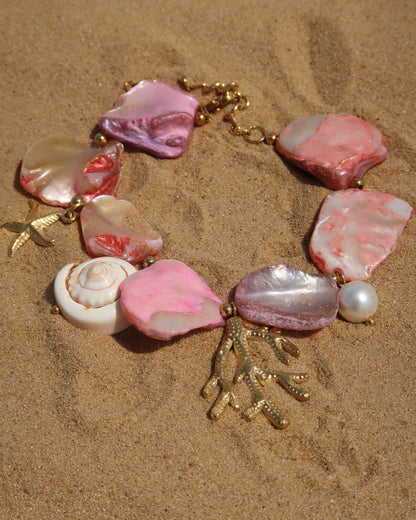 Statement armband van roze schelpen met speelse bedels