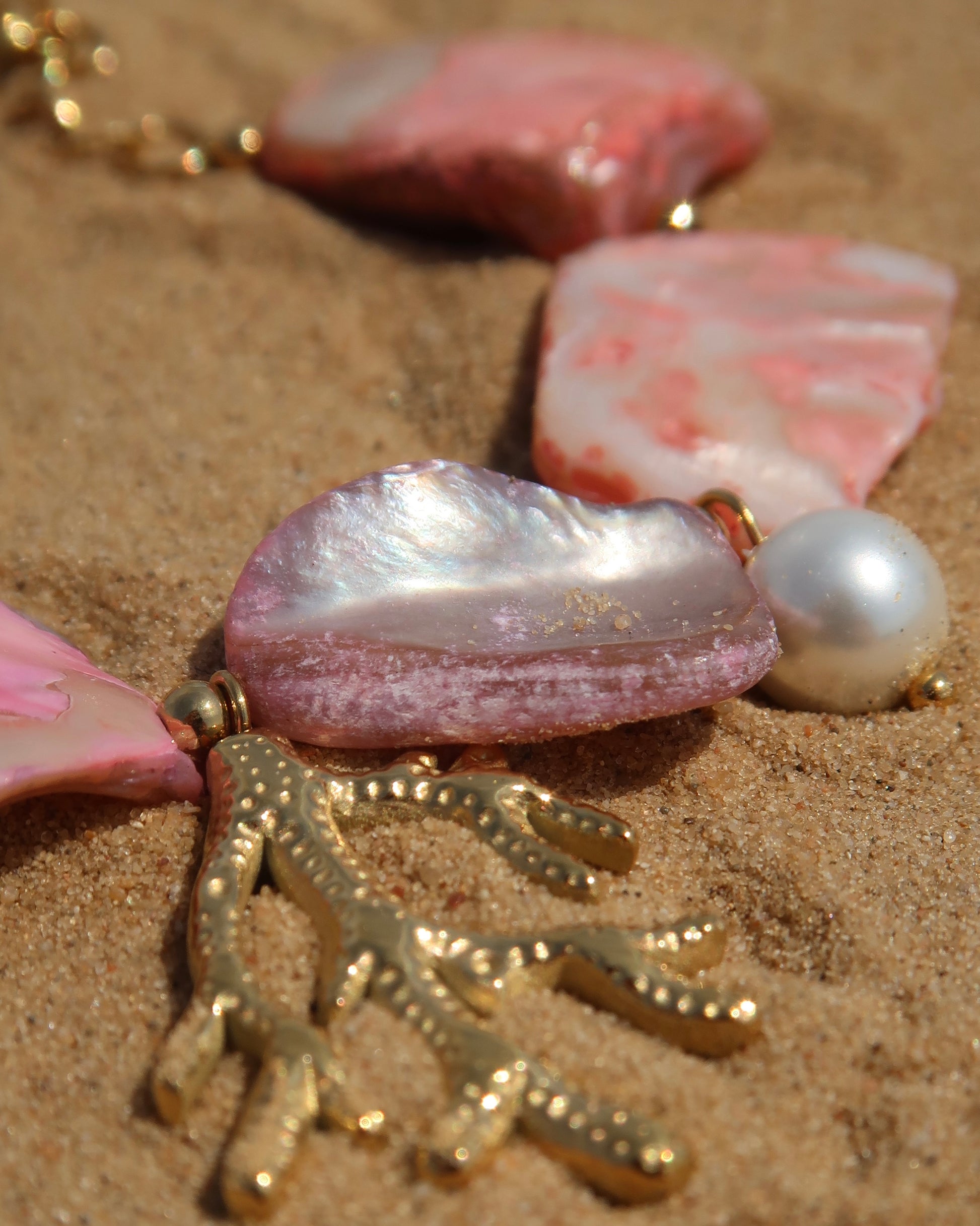 Statement armband van roze schelpen met speelse bedels